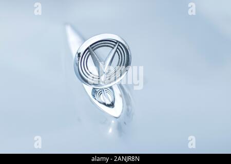 Nahaufnahme des buick-Autoemblems auf einer glänzend grauen Kapuze, die Himmel und Umgebung reflektiert Stockfoto