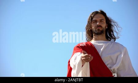 Jesus im weißen Gewand stretching Hand gegen den blauen Hintergrund und bittet Herrn helfen Stockfoto