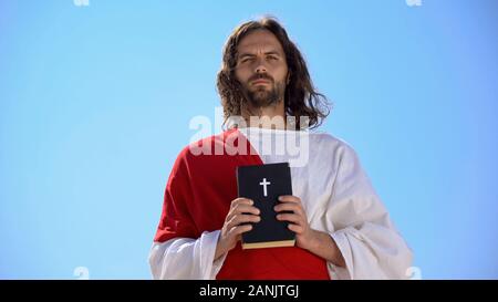 Der heilige Mann mit Bibel gegen Himmel, Glaube und Religion, Katholizismus Stockfoto
