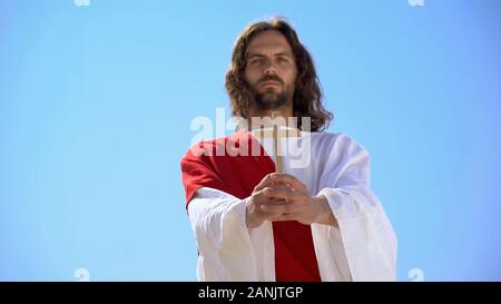 Jesus Holding hölzernes Kreuz gegen den blauen Himmel, die Bekehrung zum Christentum, Taufe Stockfoto