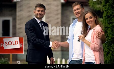 Immobilienmakler zitternden Hand von Mann, Frau, Haus, Schlüssel, gutes Angebot, Einkommen Stockfoto
