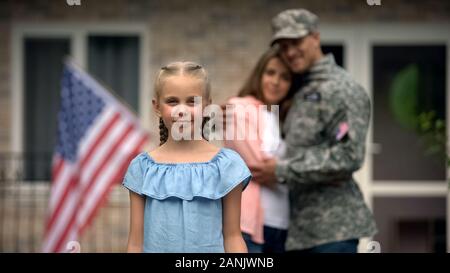 Kleines Mädchen lächelnd, amerikanische Fahne Streik vor Eltern, die Patrioten, die Familie Stockfoto