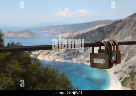 Romantisches Liebesschloss oder Liebesschloss, am Zaun mit Blick auf die Küste in Zakynthos, Griechenland befestigt Stockfoto