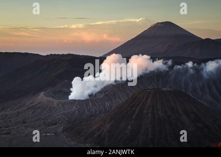 Blick auf den Mount Bromo mit Rauch beim Sonnenaufgang von Penanjakan Sunrise Point, East Java. Bromo gesehen ist der bekannteste Berg in Ost Java mit der geschäftigsten Besuche jedes Jahr. Mount Bromo hat eine Höhe von 2.392 Meter über dem Meeresspiegel und ist in vier Regierungsbezirke, nämlich Probolinggo, Pasuruan, Lumajang und Malang Regency befindet. Stockfoto