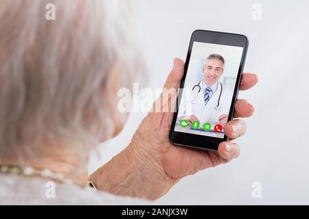 Ältere Frau Videokonferenzen mit Arzt auf dem Smartphone zu Hause Stockfoto