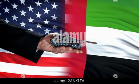 Offizielle hand Spielzeug Tank gegen USA und VAE Fahnen, militärischen Konflikt Stockfoto