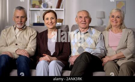 Freundliche ältere Freunde sitzen auf dem Sofa und lächelte Kamera, glücklichen Ruhestand Stockfoto