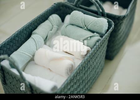 Korb mit gewalzten frische Handtücher auf Tabelle in Spa. Stockfoto