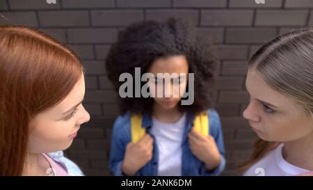 Grausame Schülerinnen suchen, Angst schwarzen Klassenkameradin Hintergrund, Missbrauch Stockfoto