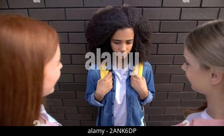 Weibliche Jugendliche auf der Suche nach jüngeren schwarzen Schulfreund, Mobbing, Missbrauch Stockfoto