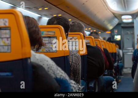 Fahrgäste, die auf der Flugzeugkabine. Menschen gefüllt Flugzeug der Fluggesellschaft Raynair Lowcost. Foto Flugzeug mit Passagieren Stockfoto