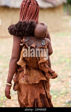 Himba Baby von Frau, Kaokoveld, Namibia Stockfoto