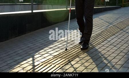 Blinder Spaziergang entlang taktiler Pflasterung, sicheren städtischen Navigation für Blinde und Sehbehinderte Stockfoto