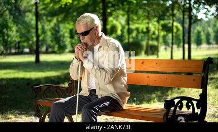 Blinde Menschen allein sitzt im Park gedrückt, die sozial benachteiligten Bevölkerung Stockfoto