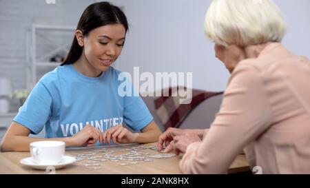 Weibliche Aktivist und älterer Frau Rätsel sammeln, Alzheimer-krankheit Bewusstsein Stockfoto