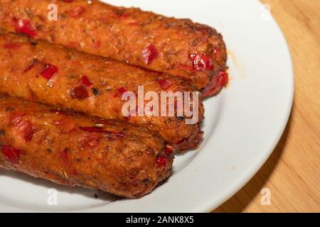 Vegetarische Nahrung - Linda McCartney vegetarisch Chorizo und rote Paprika Würstchen auf einem Teller Stockfoto