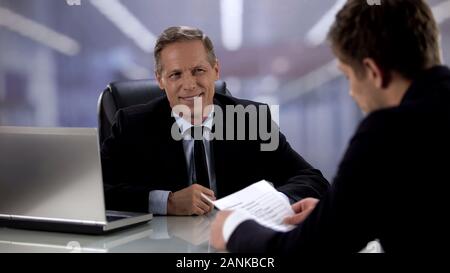 Optimistisch männlichen Chef lächelnd in die Bewerberländer beim Vorstellungsgespräch, gutes Ergebnis Stockfoto
