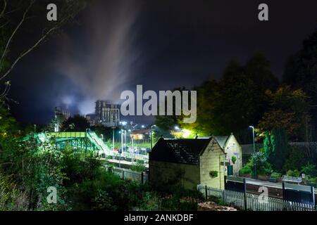 Eine Nacht Szene von Potsdam Hauptbahnhof mit Wolken von Dampf und Rauch aus den Schornsteinen der Kronospan Stockfoto