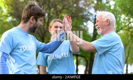 Lächelnd freiwilligen High Five geben, Zusammenarbeit Geste, Umwelt Projekt Stockfoto