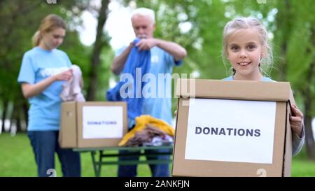 Lächelnde Mädchen holding Spendenbox, freiwillige Vorbereitung humanitäre Hilfe, Hilfe Stockfoto