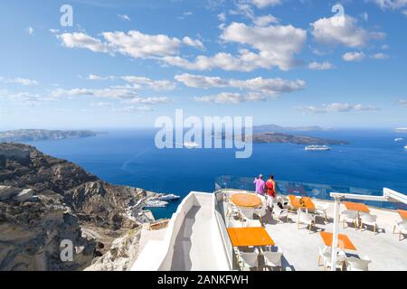 Ein paar uhren Kreuzfahrtschiffe im Hafen fahren von einer Terrasse mit Blick auf die Ägäis in Thira, auf der Insel Santorin, Griechenland. Stockfoto