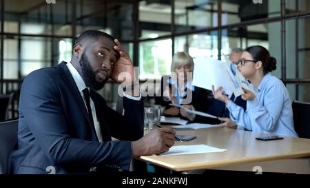 Männliche Mitarbeiter der Firma müde hören auf zu schreien und Kollegen im Büro Stockfoto