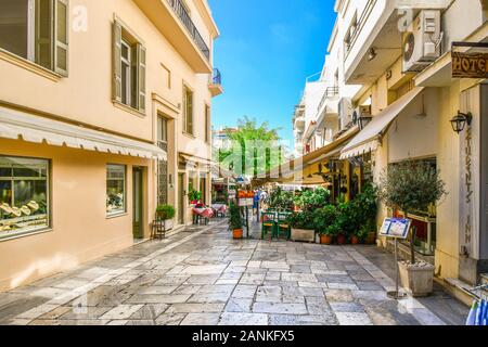 Einem malerischen Straßencafé auf einer schmalen Fußgängerzone durch die touristischen Stadtteil Plaka in der historischen Altstadt von Athen, Griechenland. Stockfoto