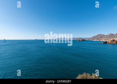 Playa de La Reya Bucht in Puerto de Mazarron, Murcia, Costa Calida, Spanien, EU. Blaue Wasser des Mittelmeers an einem strahlend blauen Himmel. Segelboot Stockfoto