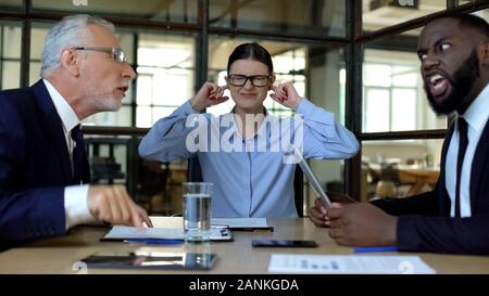 Betont weibliche Arbeitnehmer, die Ohren Gefühl der Argumentation Büro Kollegen müde Stockfoto