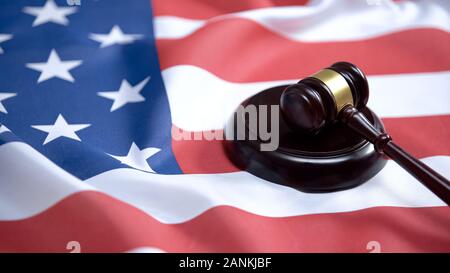Hammer anschlagen auf soliden Block gegen die amerikanische Flagge, Rechtsprechung, Justiz Stockfoto