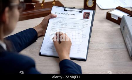 Weibliche Botschaft Arbeiter Kontrolle Visa Application office, Einwanderung Verordnung Stockfoto