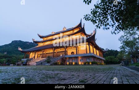 Ninh Binh, Vietnam - Mai 2019: Sonnenuntergang über die Buddhas der drei Zeiten Hall bei Nacht Stockfoto