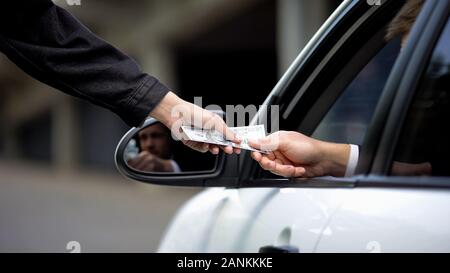 Weibliche Hand, denn Dollar von Fahrer, Parkplatz, Auto mieten, Service, bestellen Stockfoto
