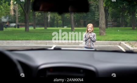 Angst kleine Mädchen stehen in der Straße vor der Fahrt Auto, Verkehr Verordnungen Stockfoto