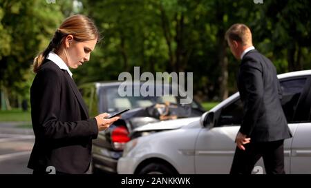 Frau Aufruf versicherung Service, man beobachten Auto beschädigen, Verkehrsunfall Stockfoto