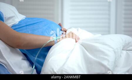 Schwangere Frau mit Decke, Gefühl, Bauchschmerzen, Risiko einer Fehlgeburt Stockfoto