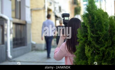 Yellow Press Journalist unter Foto von älteren Berühmtheit gehen mit jungen Mann Stockfoto
