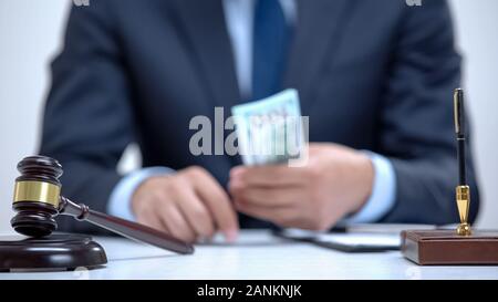 Korrupte Rechtsanwalt holding Schmiergeld in Händen, gefälschte Business-Vereinbarung, Kriminalität Stockfoto