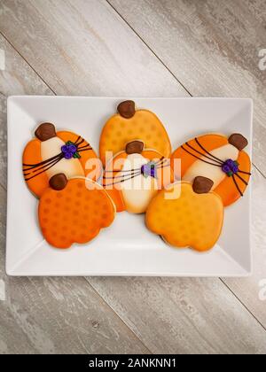 Ansicht von oben nach unten gestaltet Sugar Cookies der festlichen Herbst Kürbisse mit lila Blumen gebunden Fallen zu feiern. Stockfoto