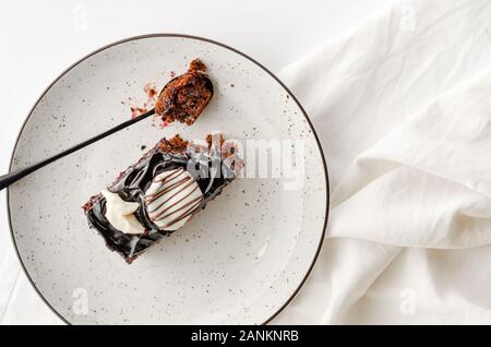 Eine Scheibe des verglasten Schokoladenkuchen auf weiße Platte. Overhead shot, kopieren Raum Stockfoto