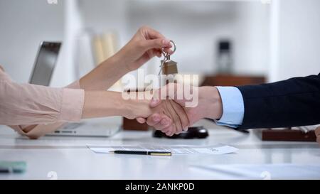 Frau Händeschütteln mit Rechtsanwalt holding Hausschlüssel, erfolgreichen Kauf, Stockfoto