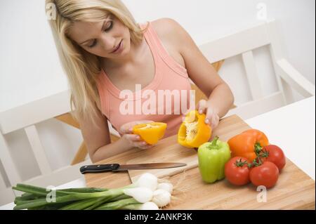 Frau schneidet Gemüse in der Küche - Frau schneiden Gemüse in der Küche Stockfoto