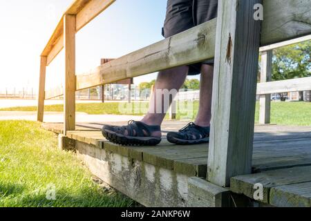 Junger Mann beiläufig auf der Promenade bei Strand Sonnenuntergang Stockfoto