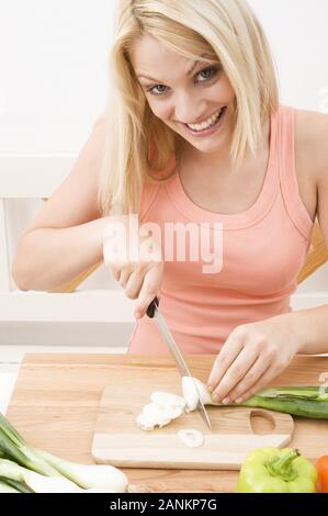 Frau schneidet Gemüse in der Küche - Frau schneiden Gemüse in der Küche Stockfoto