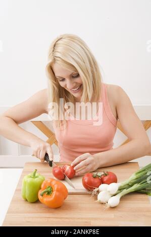 Frau schneidet Gemüse in der Küche - Frau schneiden Gemüse in der Küche Stockfoto