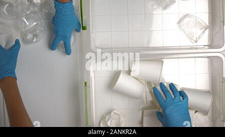 Arbeitnehmer in Handschuhe Sortieren von Papier und Pappe Einwegbecher zum Recycling line Stockfoto