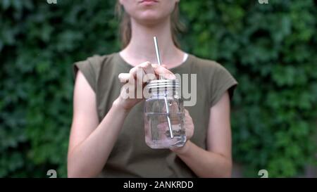 Frau trinkt Wasser aus Glas Becher, Sie wiederverwendbare sichere Materialien, Ökologie Stockfoto