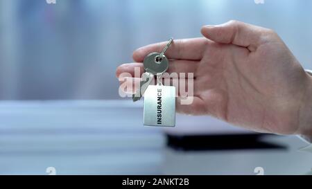 Versicherung Wort am Schlüsselbund männliche Hand geschrieben, auf Kamera, Leben Schutz Stockfoto