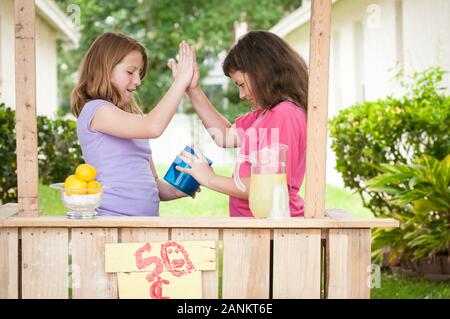 Zwei junge Mädchen mit Limonadenständer Stockfoto