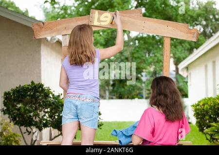 Junge Mädchen malen einen Limonadenstand Stockfoto